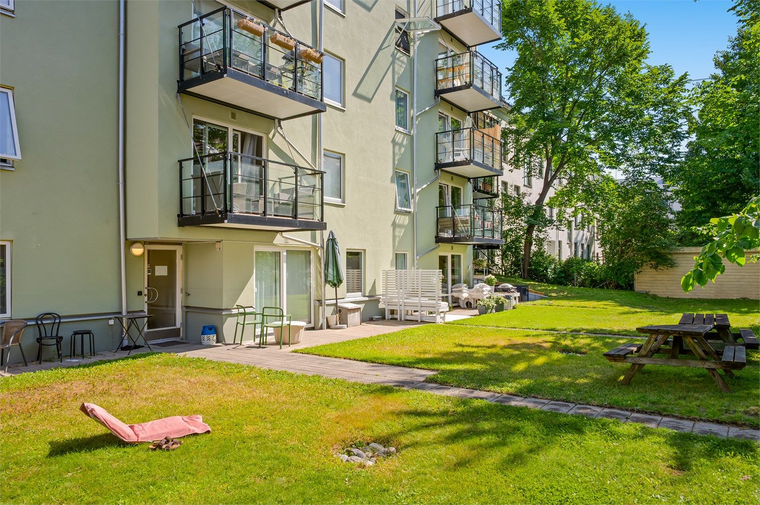 Den opparbeidede bakgården byr på grønne omgivelser og hyggelige sitteplasser – et fint sted å nyte varme sommerdager.