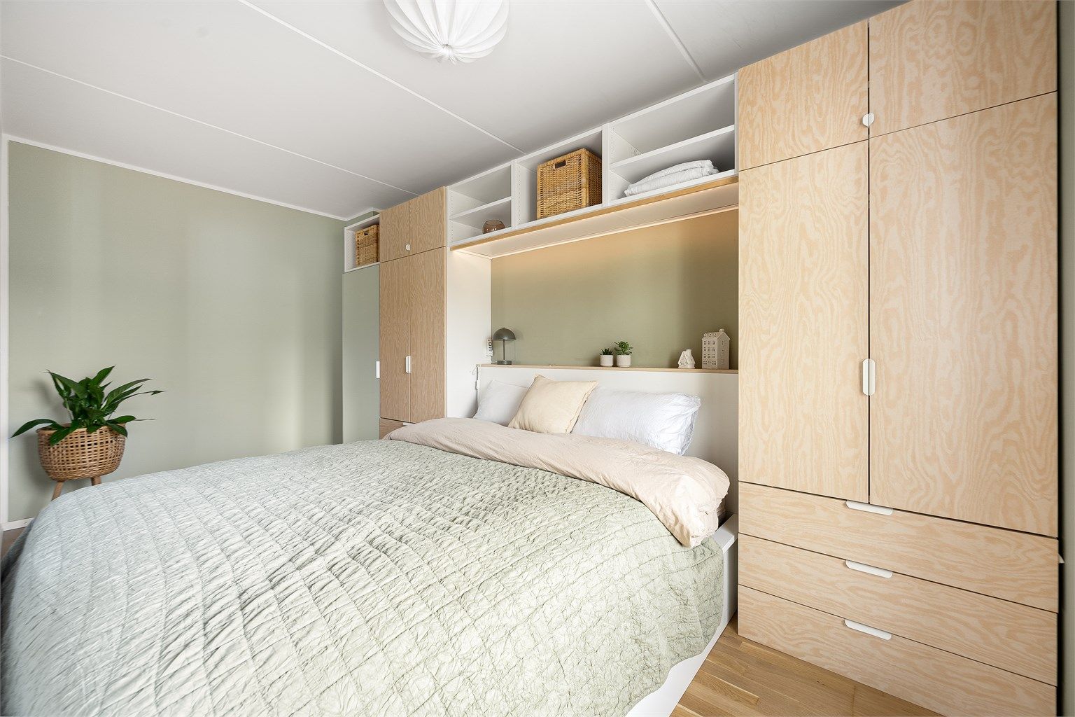 Garderoben er smart utformet med en kombinasjon av skap, skuffer og åpne hyller som utnytter rommets fulle høyde.