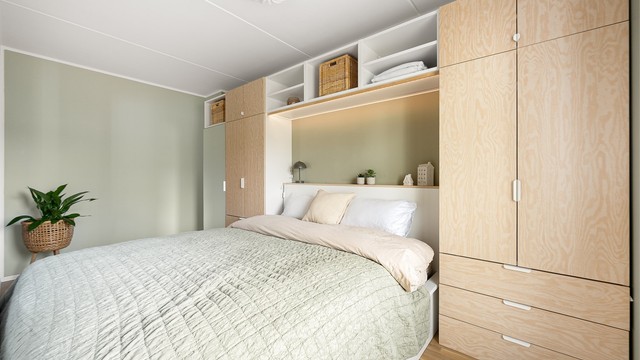 Garderoben er smart utformet med en kombinasjon av skap, skuffer og åpne hyller som utnytter rommets fulle høyde.