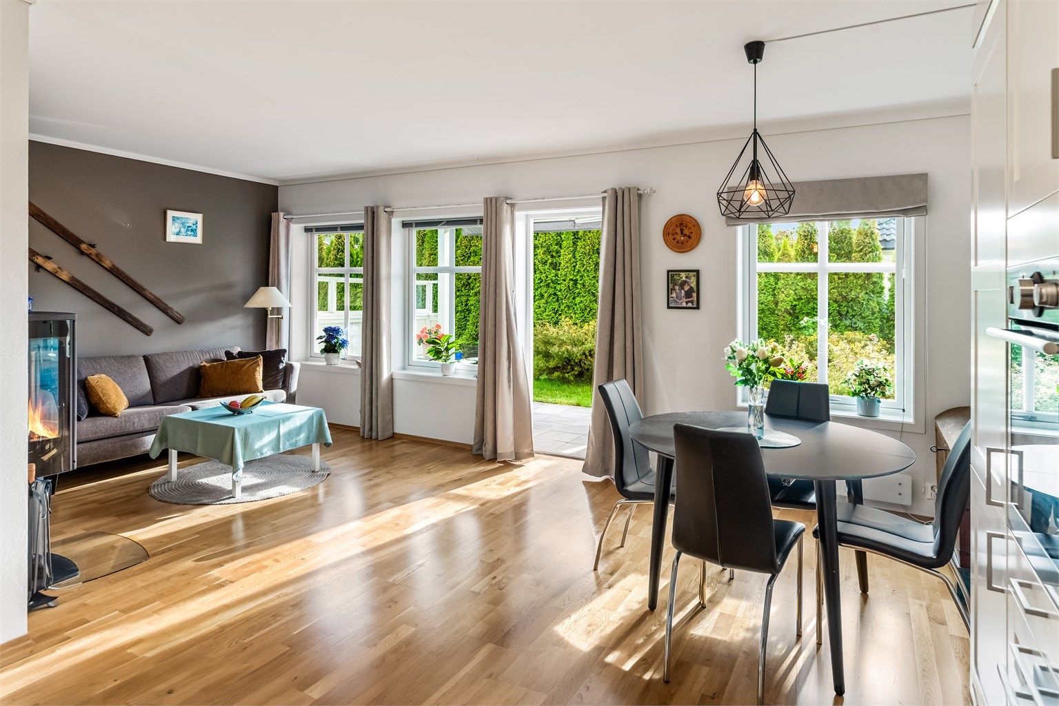 Stuen har god plass til både sofagruppe og spisebord, med peisovn som gir lun varme.