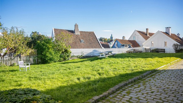 Fellesarealer med gressplen og brostein i det vernede området.
