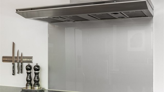 Kjøkkenet er utstyrt med integrert platetopp og en vegghengt ventilator. Glassplaten bak kokesonen beskytter veggen.