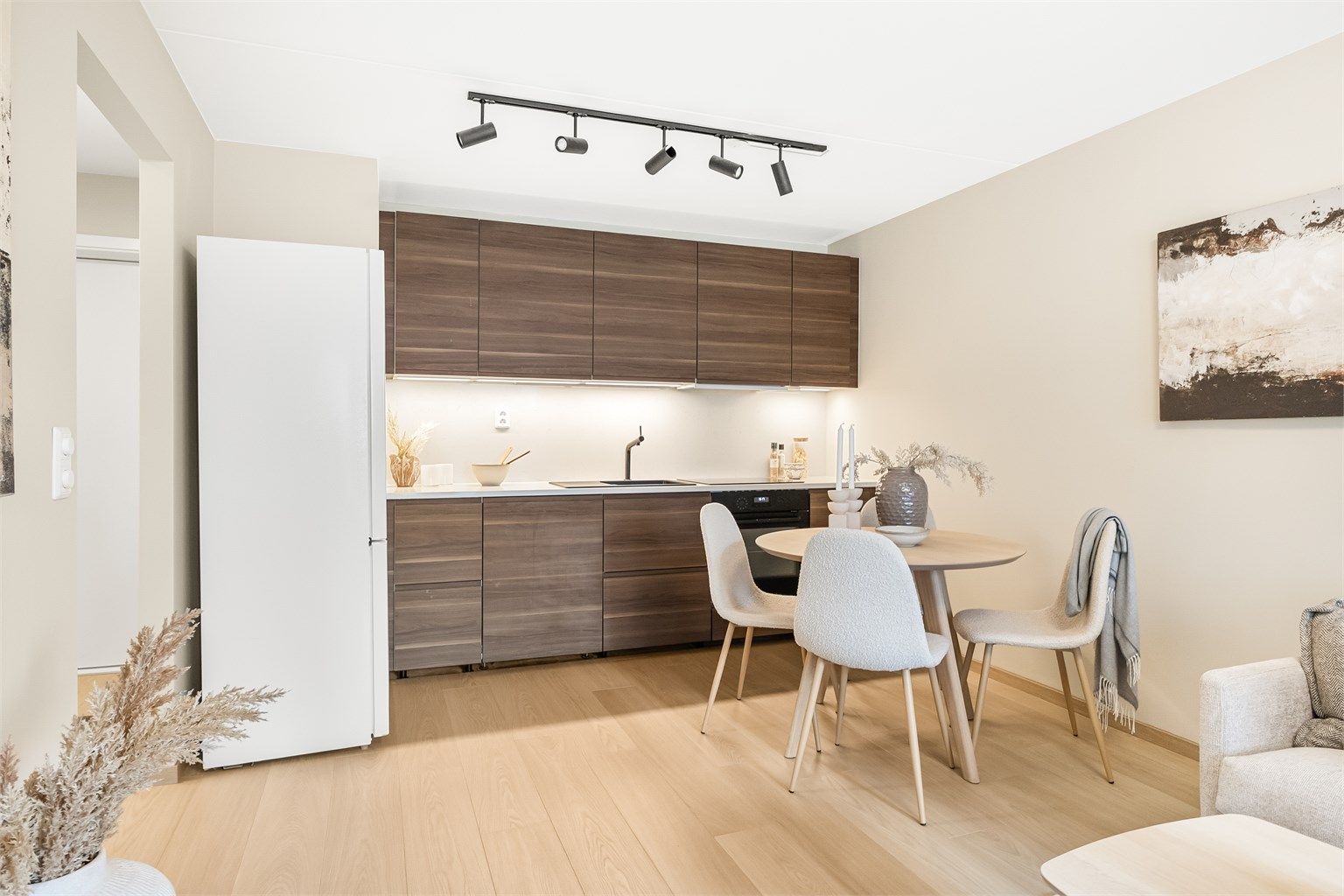 Delikat kjøkken fra 2022 med åpen løsning mot stue. Kjøkkeninnredningen er fra IKEA og har glatte fronter med benkeplate av stein.
