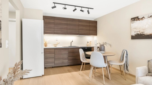 Delikat kjøkken fra 2022 med åpen løsning mot stue. Kjøkkeninnredningen er fra IKEA og har glatte fronter med benkeplate av stein.