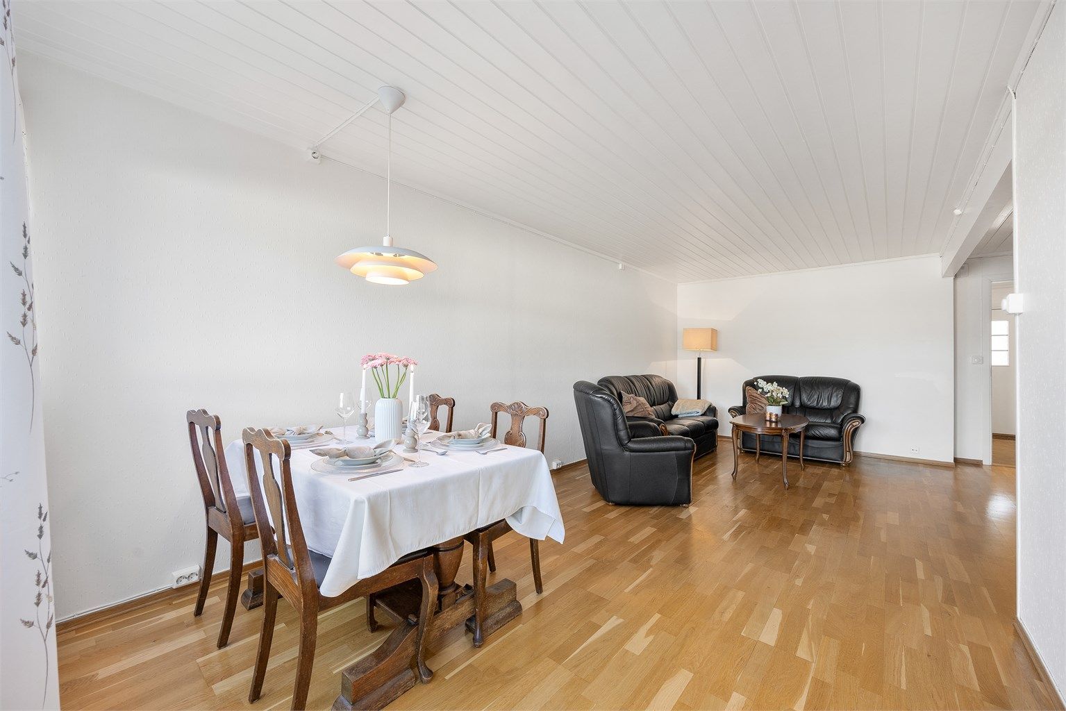 Stuen er romslig og har plass til både en stor sofagruppe og et langbord i spisestuen.