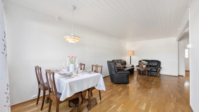 Stuen er romslig og har plass til både en stor sofagruppe og et langbord i spisestuen.