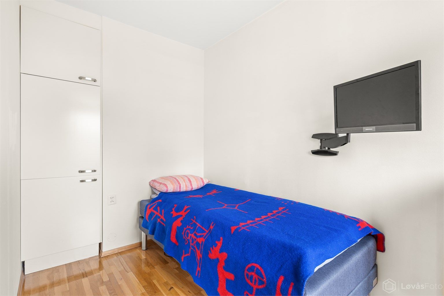 Soverom med parkett på gulvet og integrert garderobeskap