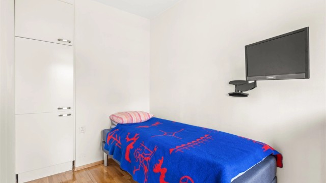 Soverom med parkett på gulvet og integrert garderobeskap