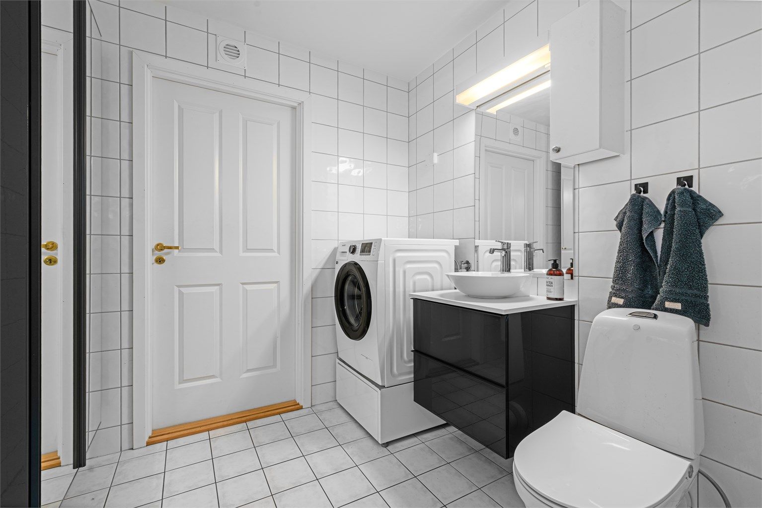Badet er utstyrt med vegghengt servantinnredning og har opplegg for vaskemaskin.
