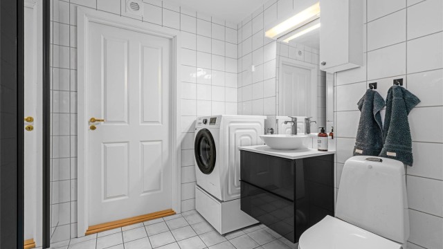 Badet er utstyrt med vegghengt servantinnredning og har opplegg for vaskemaskin.