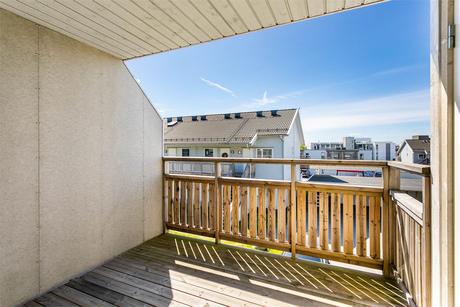 Skjermende vegger og et nær heldekkende overbygg gjør det mulig å benytte balkongen selv når sommerværet ikke er på sitt aller beste.