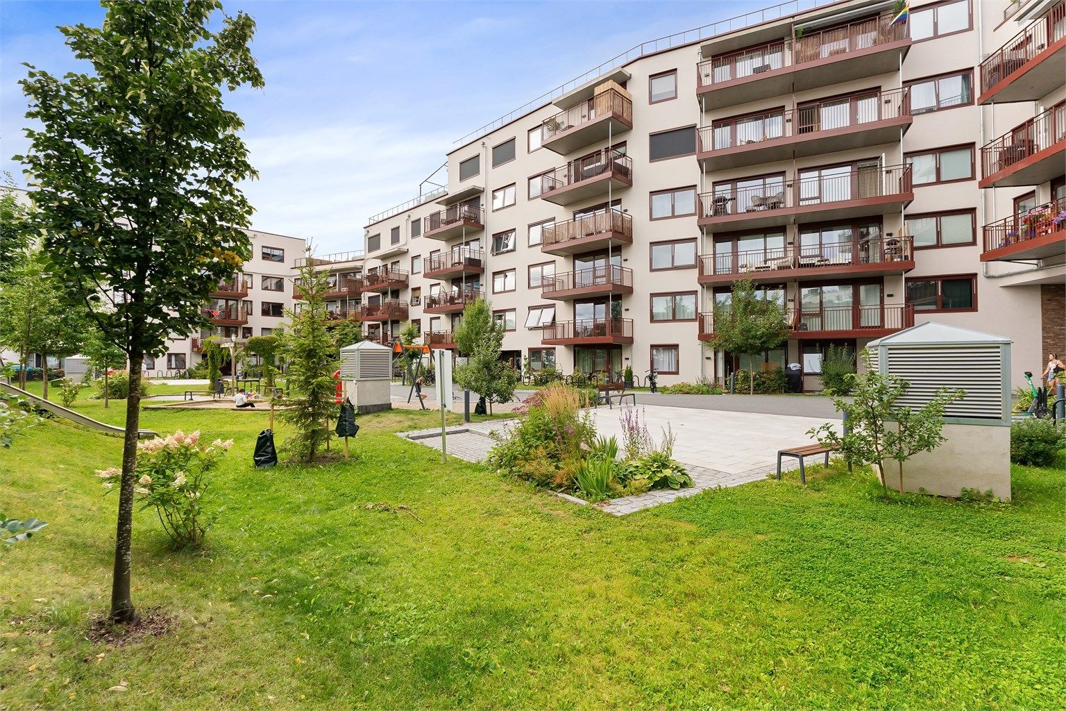 Felles bakgård som er opparbeidet med lekeplass, plen og beplantning.