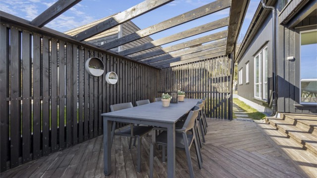 Terrassen er bygget i tre i fiskebeinsstil under pergolaen.