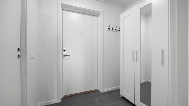 Entré med flislagt gulv og plass til garderobeløsning.