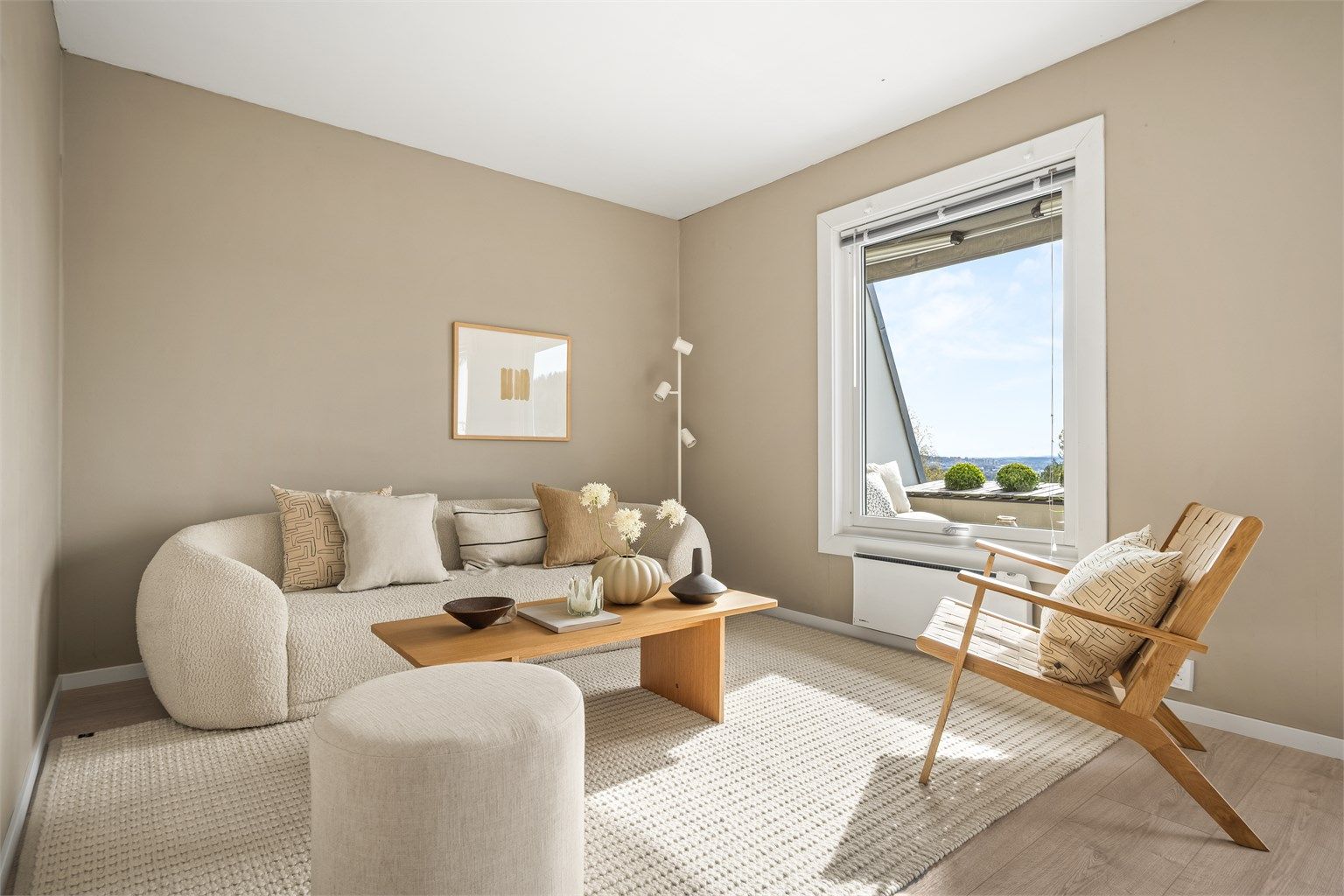 De malte overflatene og laminatgulvet gir et helhetlig og lyst inntrykk.