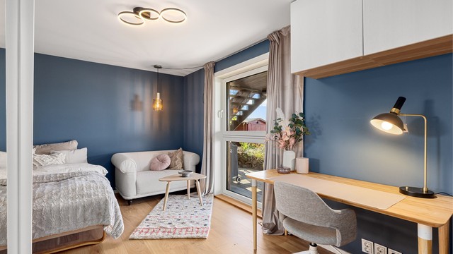 Det første soverommet i første etasje har parkett med gulvvarme og plass til seng og skrivebord.