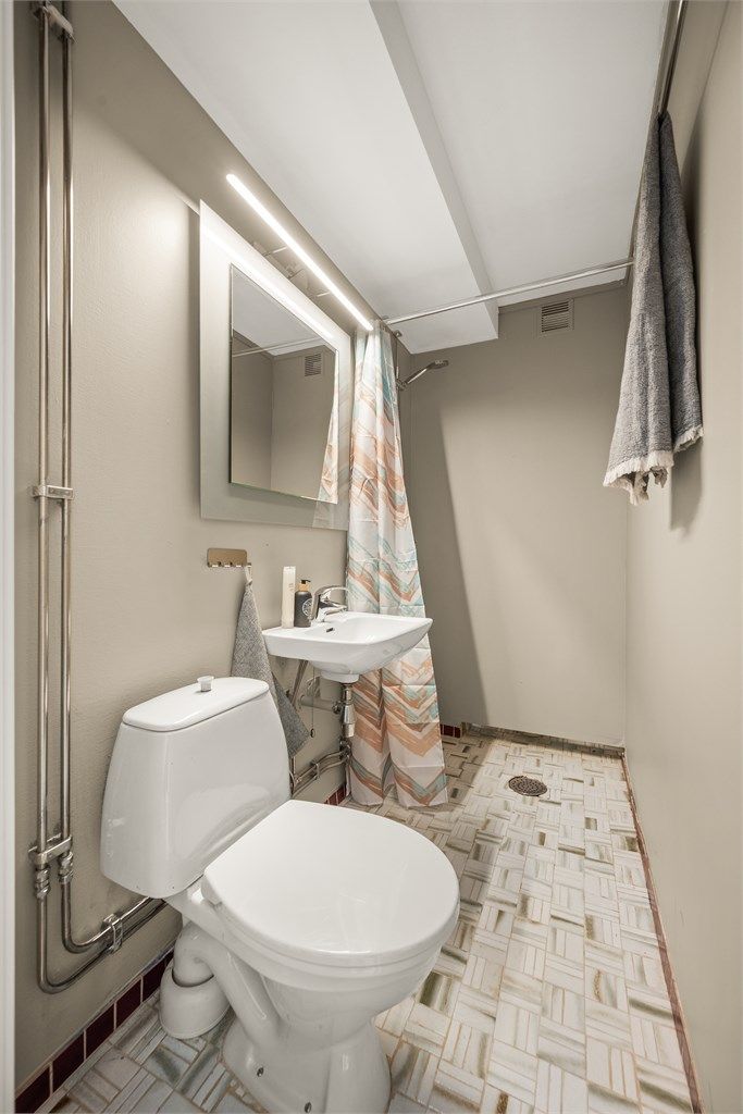 Leilighetens andre bad, også dette fra byggeår. Rommet har toalett, servant og dusjnisje.