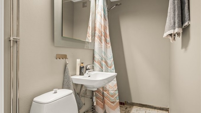 Leilighetens andre bad, også dette fra byggeår. Rommet har toalett, servant og dusjnisje.