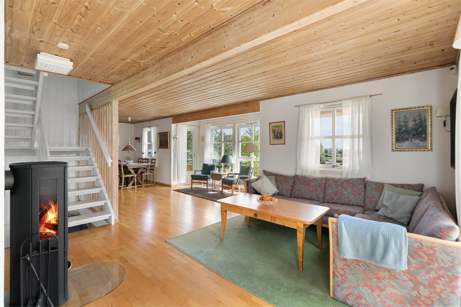 Stuen er romslig og har flere soner, med plass til både sofagruppe og lesekrok.