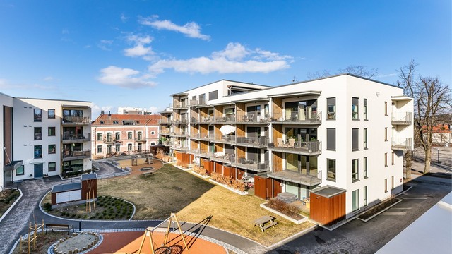 Utsyn over Skarmyrakvartalets parkmessige tun, med lekeapparater og stor tumleplass for de yngste beboerne.