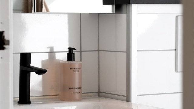 Badet er også utstyrt med nedfelt servant med underskuffer, speilskap, opplegg for vaskemaskin og vegghengt toalett.