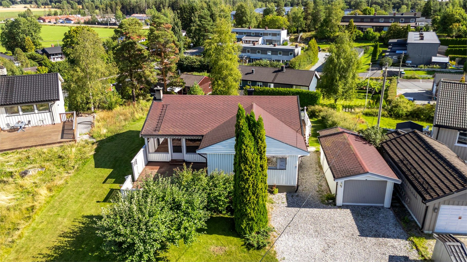 Oversikt over eiendommen med garasje og gårdsplass.