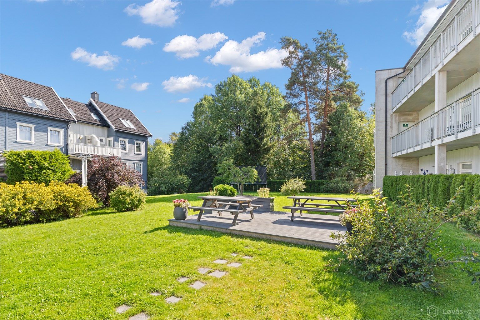 Fellesarealene er pent opparbeidet med plenarealer, beplantning, sittegrupper og trampoline.