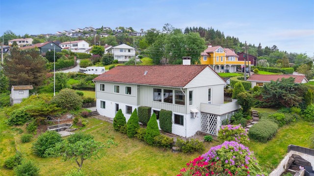 Stor og innholdsrik tomt med velstelt hage med flott beplantning, plenarealer og flere fine områder for lek og hageglede