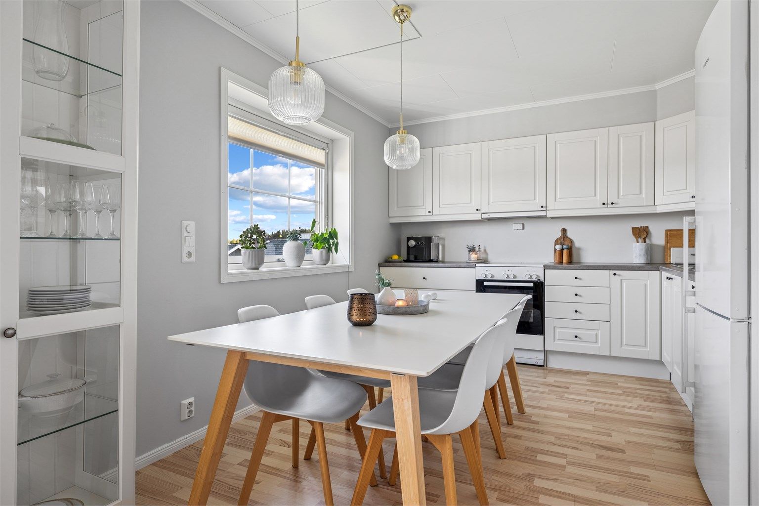 Kjøkkenet er moderne og funksjonelt med lyse fronter, grå benkeplate og god plass til både oppbevaring og matlaging.