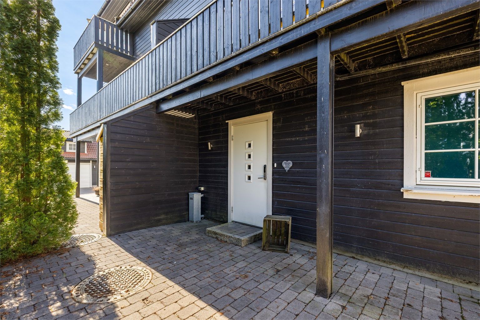 Overbygget inngangsparti med trappefri adkomst. Ytterdøren er utstyrt med Yale Doorman kodelås for en nøkkelfri hverdag.