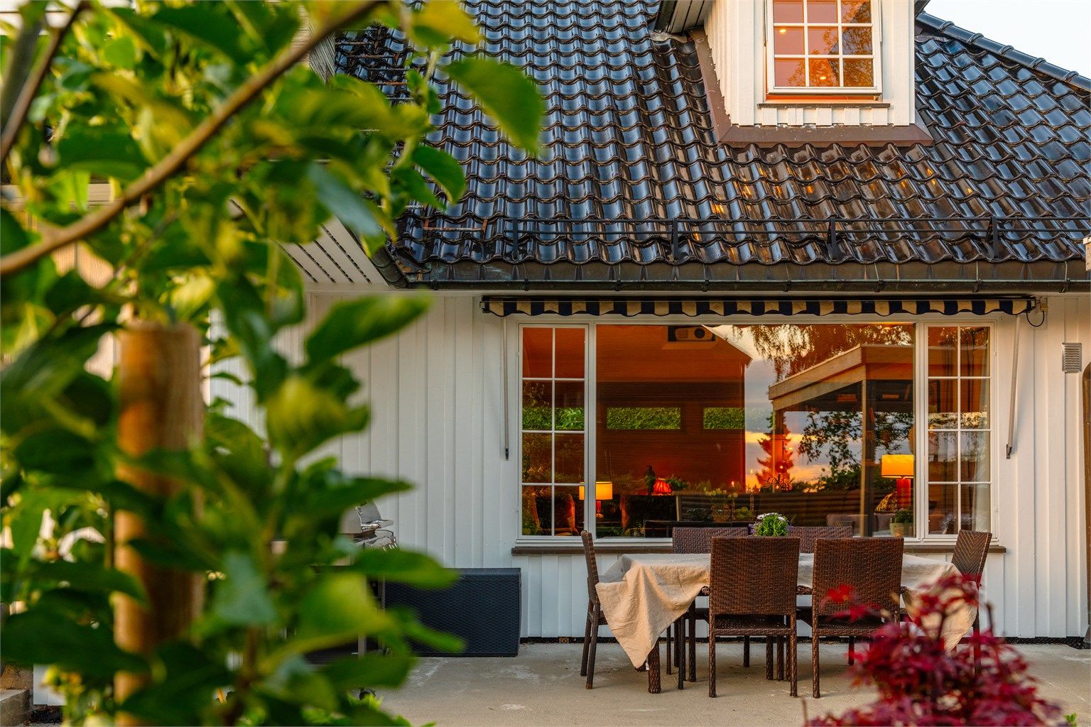 Stort vindu i stuen med hyggelig utsyn over hagen og uteplassene og hagen.