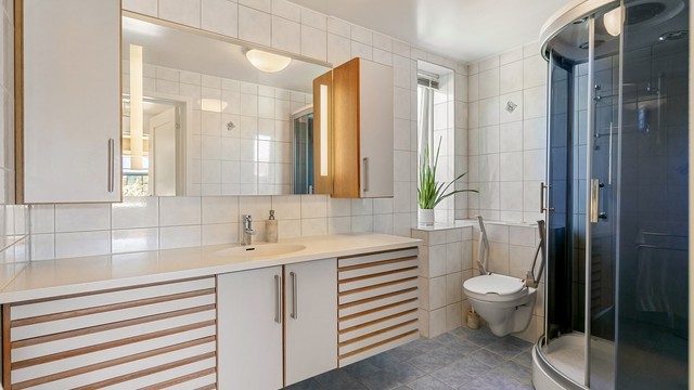 Badet i andre etasje har flislagt gulv med gulvvarme og flislagte vegger.
