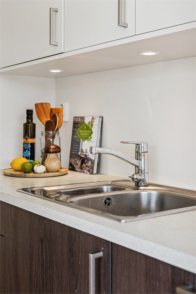 Det er nedfelt oppvaskkum med ett-greps armatur, benkebelysning og stikkontakter praktisk plassert over kjøkkenbenken.