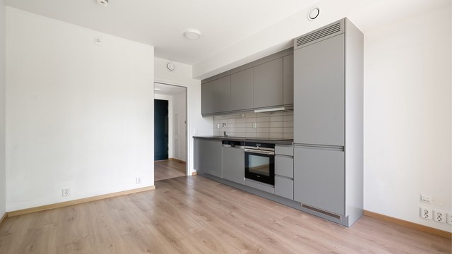 Kjøkkenet har integrerte hvitevarer med kjøl- og fryseskap, komfyr og oppvaskmaskin.