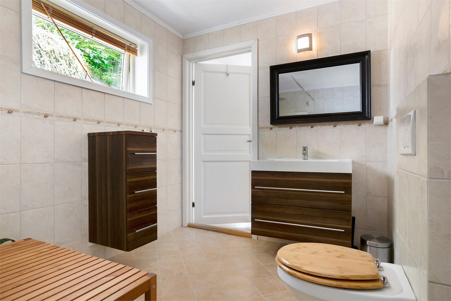 Badet i 1. etasje har flislagt gulv med gulvvarme og vegghengt toalett.