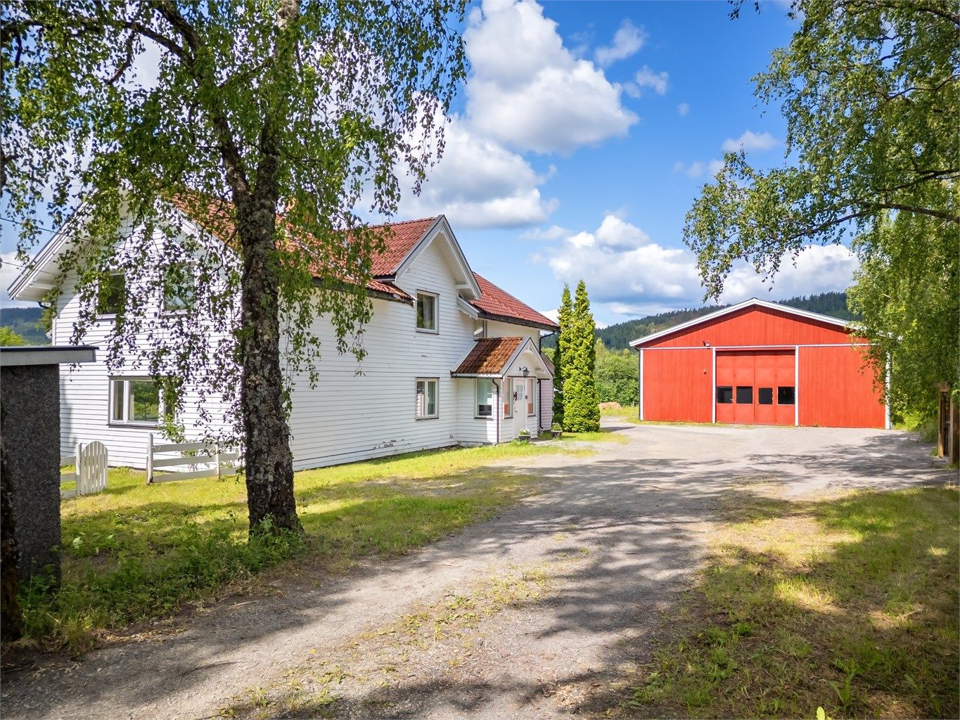 Frittstående dobbelgarasje med bod på ca. 38 kvm med jordgulv og sidehengslete garasjeporter av tre