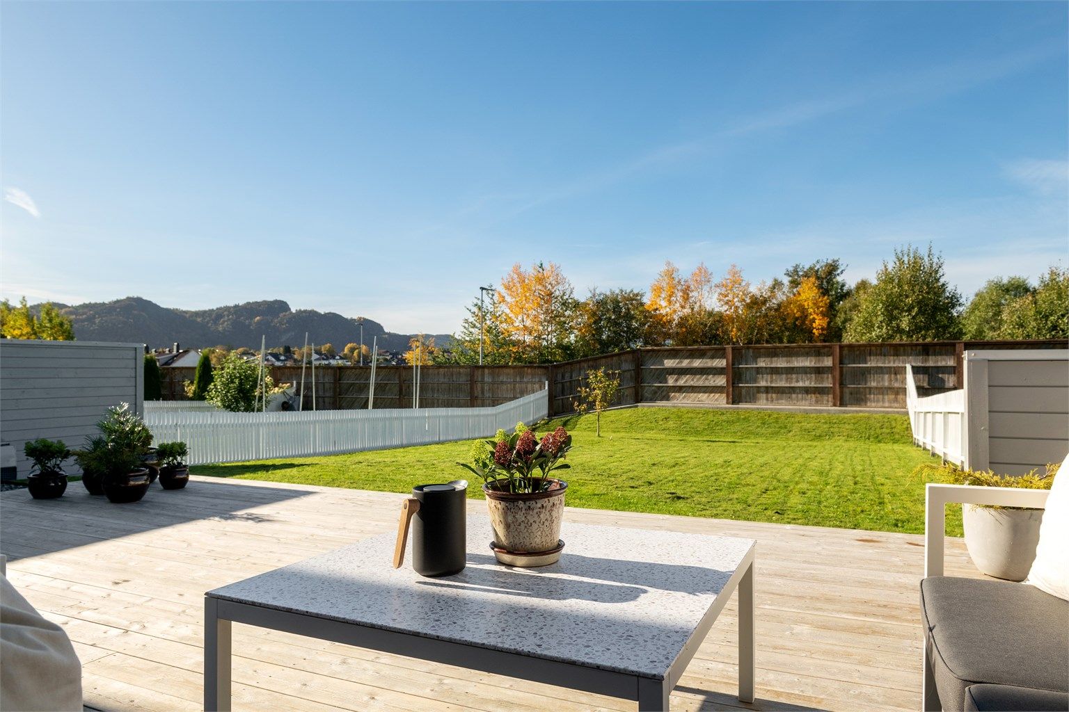 Skjermet markterrasse på bakkeplan med terrassebord i tre og god plass til utemøbler. Stor hage med gode solforhold. 