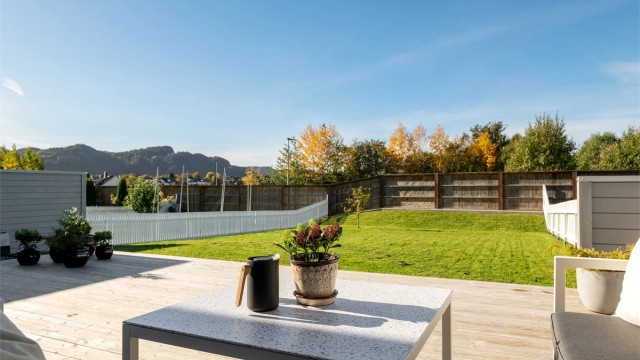 Skjermet markterrasse på bakkeplan med terrassebord i tre og god plass til utemøbler. Stor hage med gode solforhold.