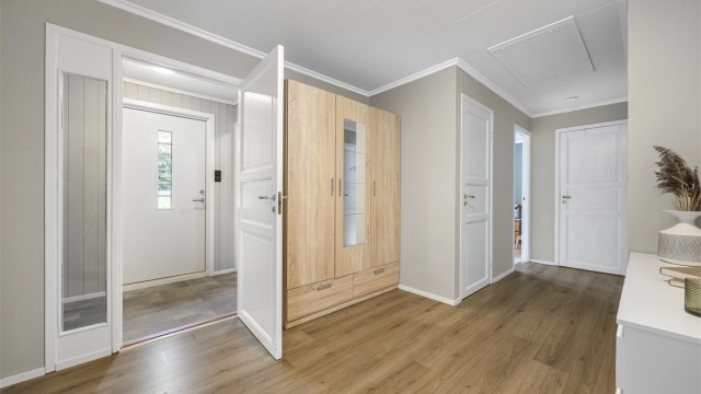 Lyst vindfang og en romslig gang ønsker deg velkommen inn i hovedetasjen.