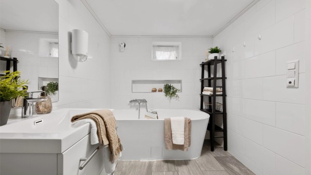 På bad er det toalett, servant med skuffer og badekar.