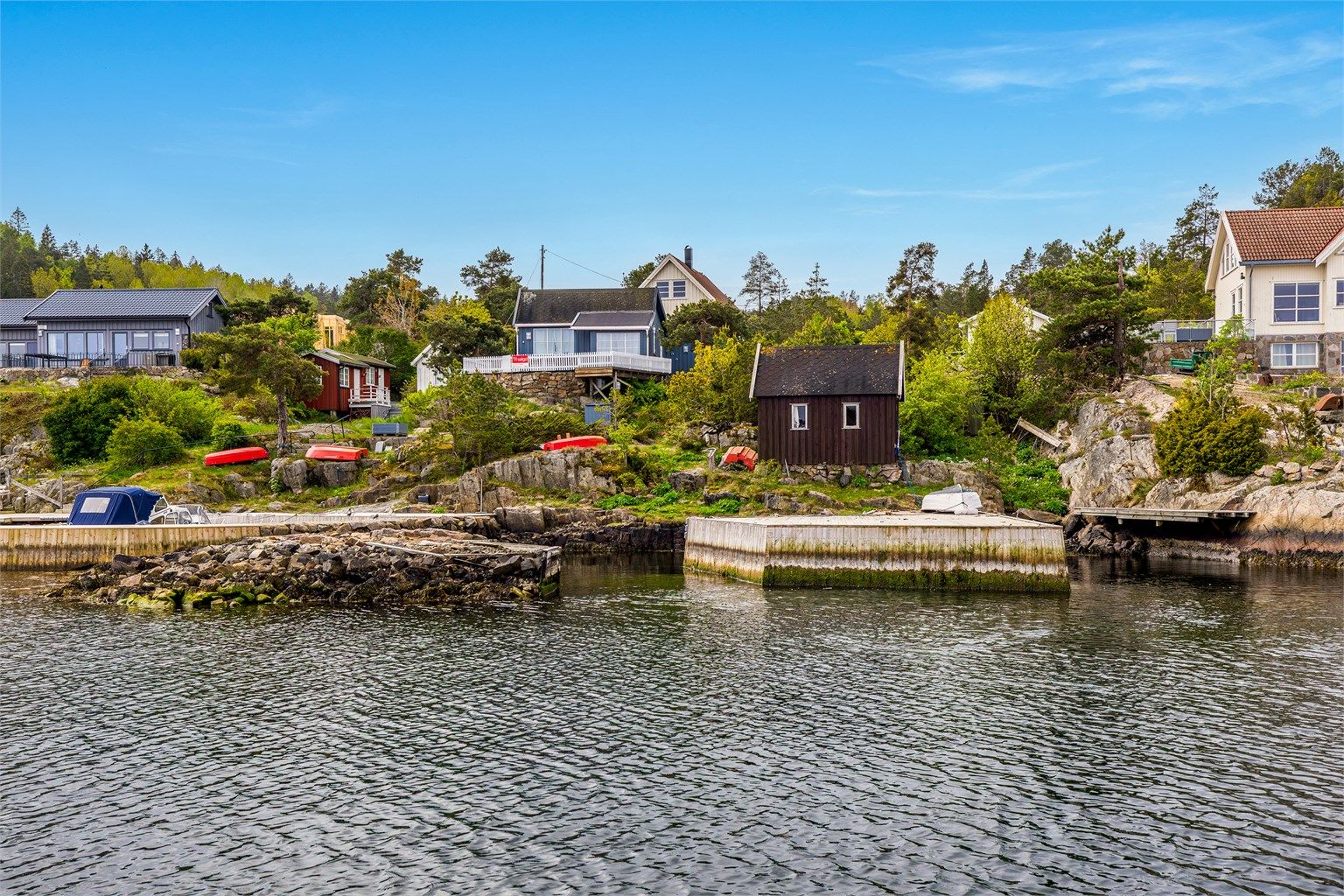 I Arøybukta ligger hytter og brygger som perler på en snor.