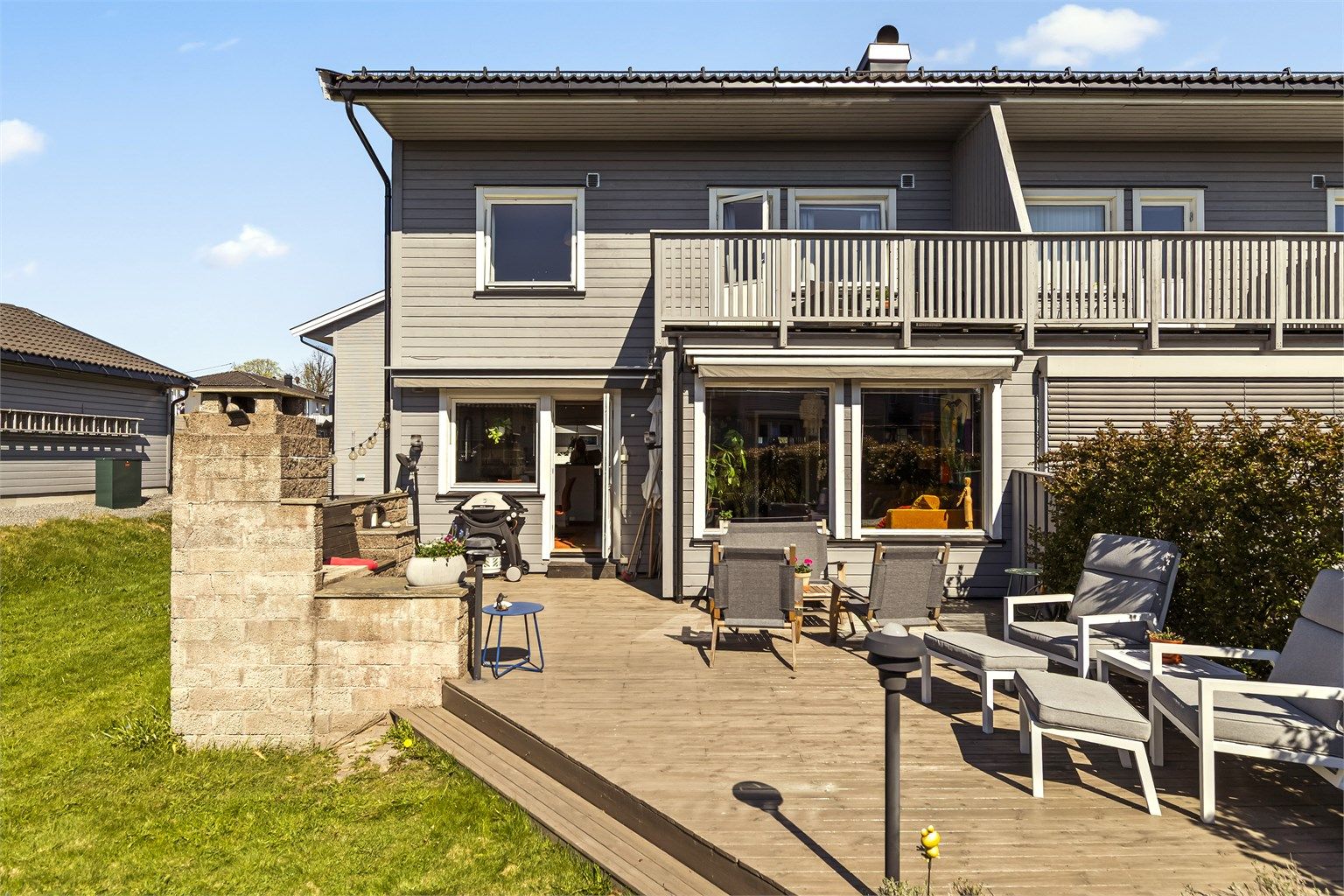 Dette enderekkehuset har en stor, sydvendt terrasse med en stemningsfull utepeis – et naturlig samlingspunkt på varme dager.