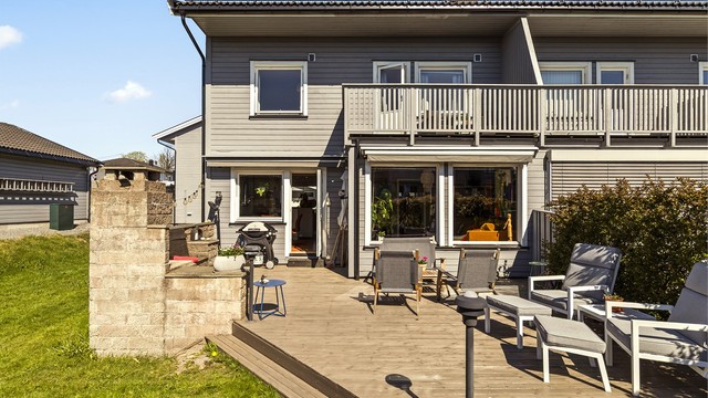 Dette enderekkehuset har en stor, sydvendt terrasse med en stemningsfull utepeis – et naturlig samlingspunkt på varme dager.