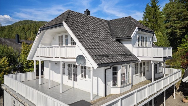 Stor balkong på 69 kvm med fliser og terrassebord på gulv.