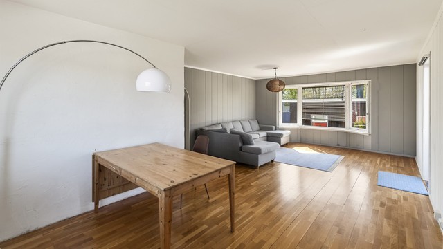Stuen har rikelig med plass til stor sofagruppe og spisebord. På gulv er det lagt parkett.