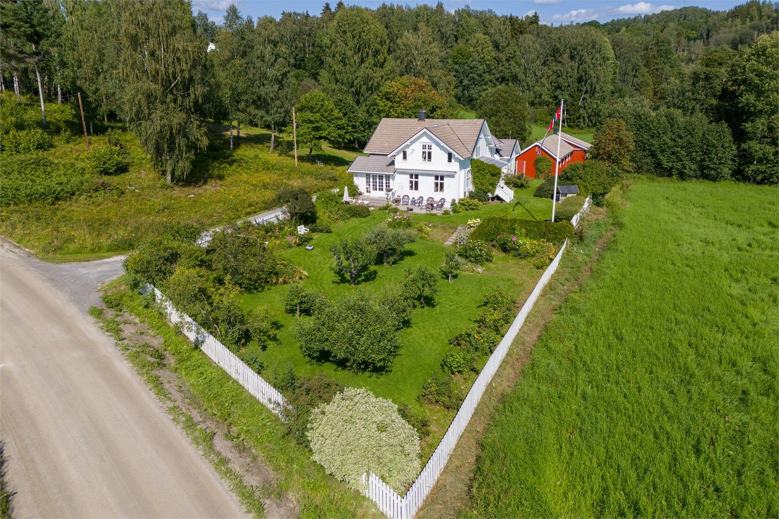 Eiendommen er særdeles flott opparbeidet med hageanlegg med frukttrær, bærbusker, blomsterbed og plen - Foto: Skildre v/Bjørnar Fjeldberg