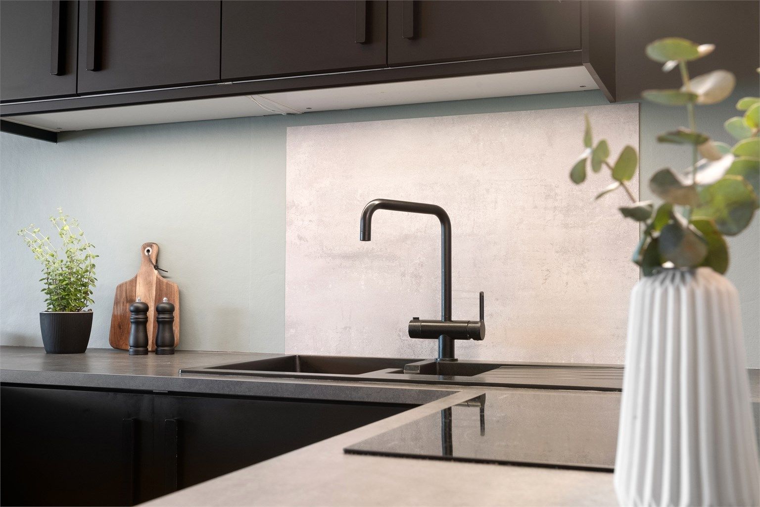 Laminert plate mellom kjøkkenbenk og overskap. 