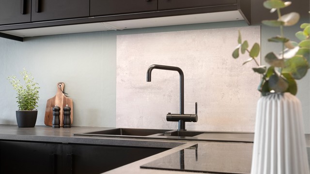 Laminert plate mellom kjøkkenbenk og overskap.