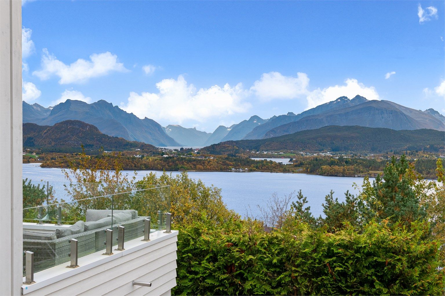 Glassrekkverket gir fri sikt over fjorden og Sunnmørsalpene.