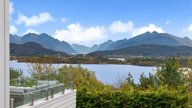 Glassrekkverket gir fri sikt over fjorden og Sunnmørsalpene.